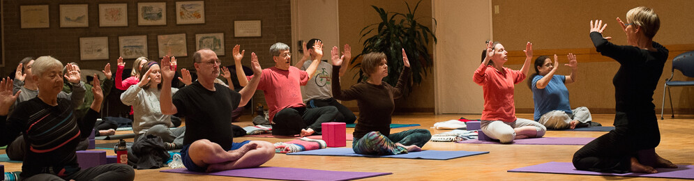 Students seated in yoga class with Judith Valerie teaching